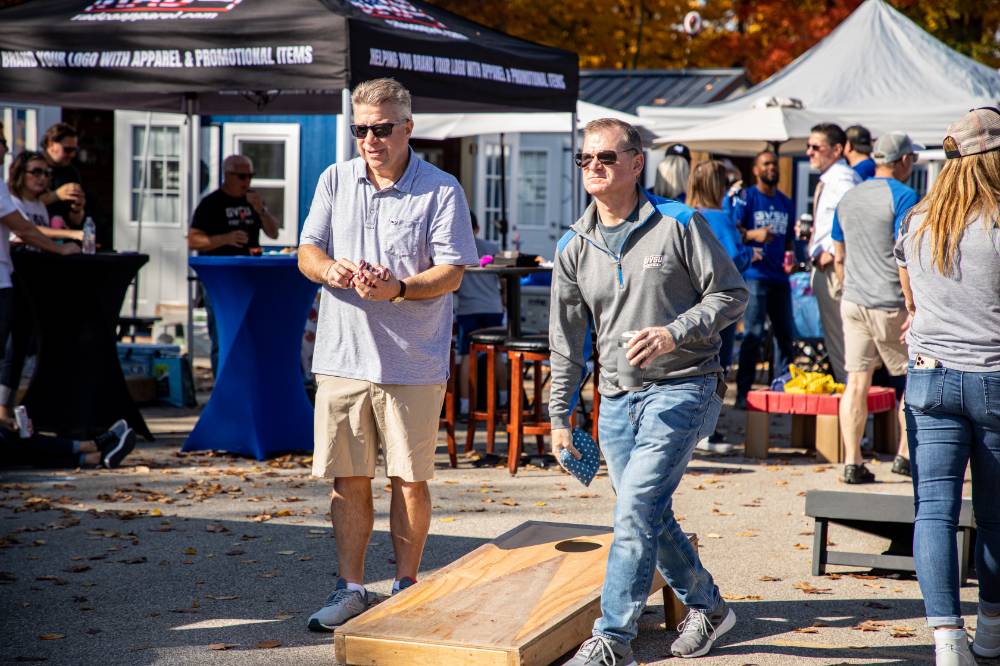 Two alums playing corn hole.